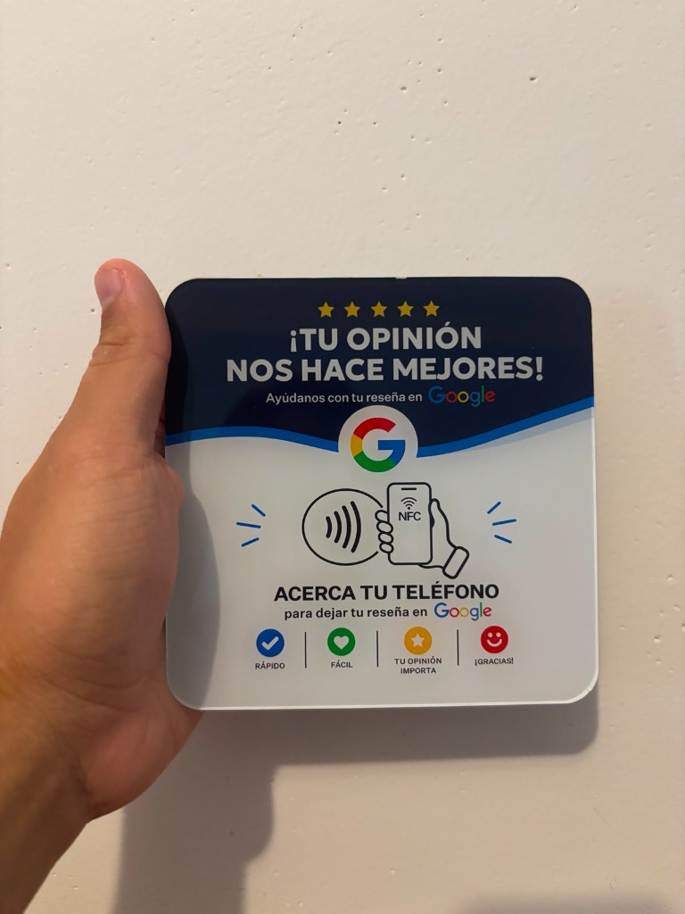 Mano sujetando la tarjeta NFC de Google Reseñas, lista para que el cliente acerque su móvil